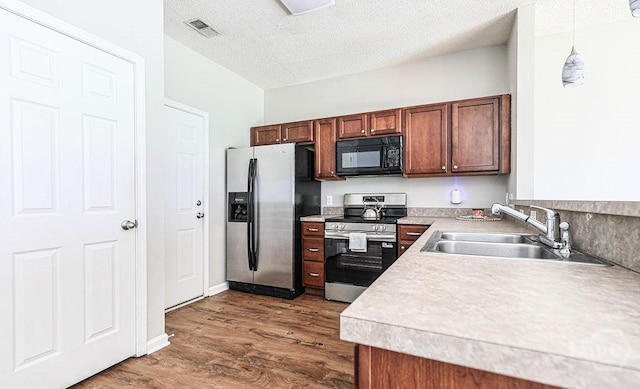 1125 Canyon Oak Loop, Richmond Hill, GA 31324 - kitchen featuring appliances with stainless steel finishes, light countertops, dark wood-style flooring, hanging light fixtures, and a textured ceiling