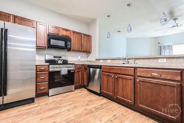 1125 Canyon Oak Loop, Richmond Hill, GA 31324 - kitchen featuring appliances with stainless steel finishes, light wood finished floors, a textured ceiling, light countertops, and a ceiling fan