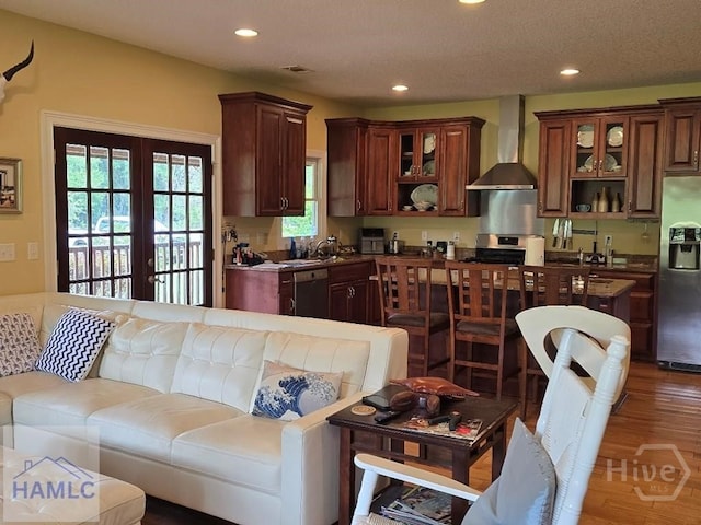 485 Lake Pamona Rd, Midway, GA 31320 - kitchen with wall chimney exhaust hood, appliances with stainless steel finishes, wood finished floors, recessed lighting, and glass insert cabinets