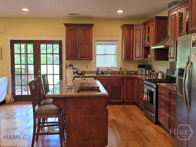 485 Lake Pamona Rd, Midway, GA 31320 - kitchen with appliances with stainless steel finishes, dark stone counters, a kitchen breakfast bar, light wood-style flooring, and recessed lighting