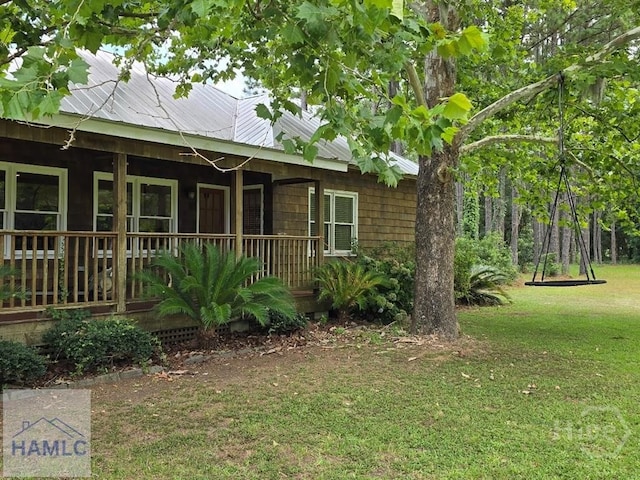 485 Lake Pamona Rd, Midway, GA 31320 - view of side of home with a yard, a metal roof, and covered porch