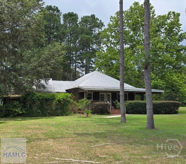 485 Lake Pamona Rd, Midway, GA 31320 - view of front of house featuring a front lawn, covered porch, and a metal roof