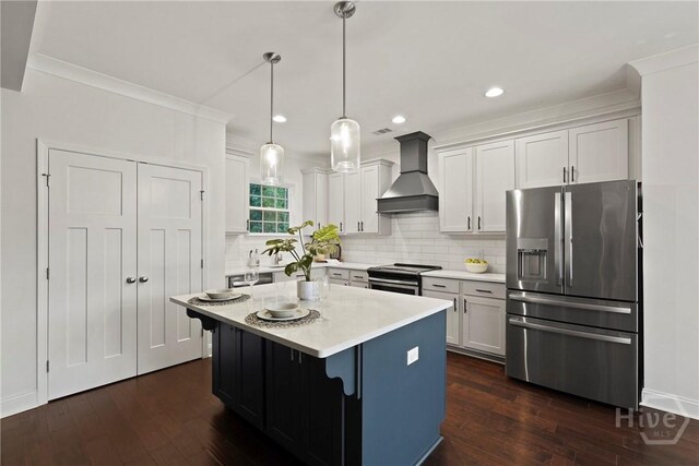 95 Simcoe Lake Dr, Richmond Hill, GA 31324 - kitchen featuring appliances with stainless steel finishes, wall chimney range hood, dark wood finished floors, light countertops, and decorative backsplash