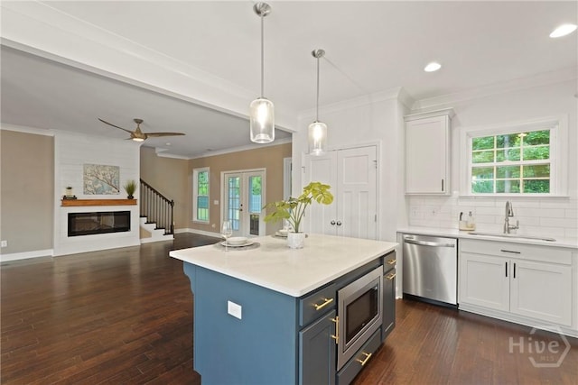 95 Simcoe Lake Dr, Richmond Hill, GA 31324 - kitchen with stainless steel appliances, crown molding, white cabinets, light countertops, and dark wood finished floors