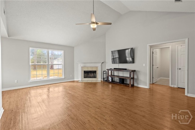 226 Cyane Ln, Guyton, GA 31312 - living room with a ceiling fan, high vaulted ceiling, wood finished floors, and a tiled fireplace