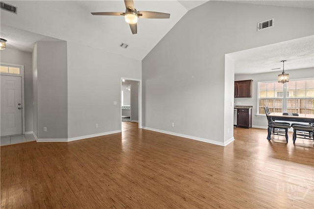 226 Cyane Ln, Guyton, GA 31312 - unfurnished living room with high vaulted ceiling, a ceiling fan, wood finished floors, and a chandelier