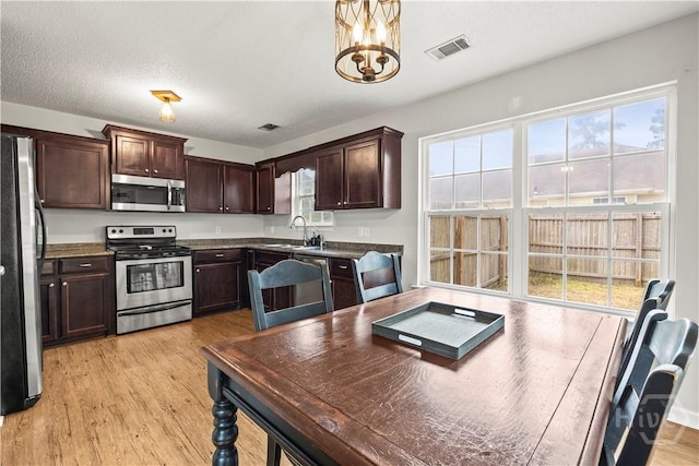 226 Cyane Ln, Guyton, GA 31312 - kitchen with stainless steel appliances, dark brown cabinets, light wood finished floors, and dark countertops