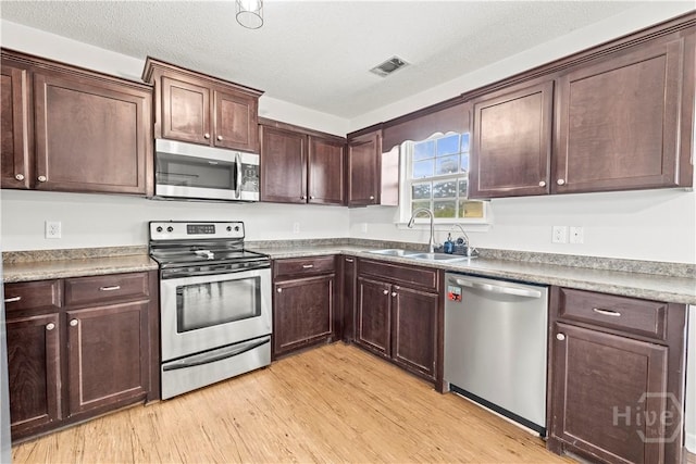 226 Cyane Ln, Guyton, GA 31312 - kitchen with stainless steel appliances, dark brown cabinets, and light wood-style flooring