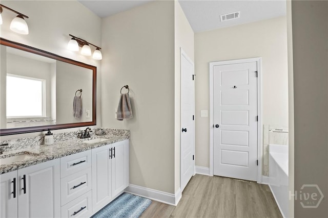 328 Providence Trce, Statesboro, GA 30461 - bathroom with wood finished floors, double vanity, and a garden tub