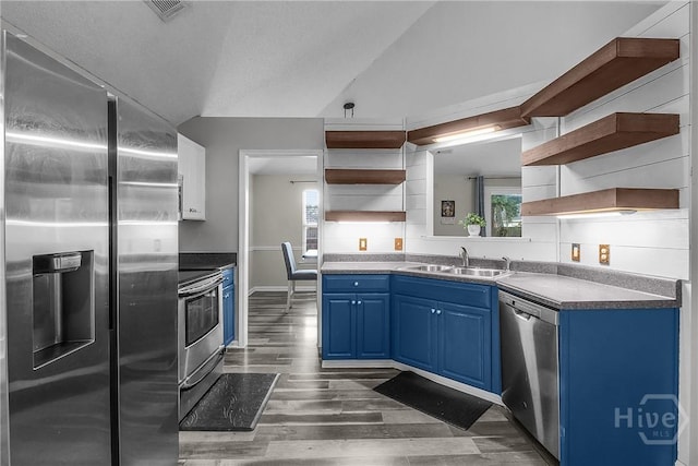 175 Salt Landing Cir, Savannah, GA 31405 - kitchen featuring open shelves, stainless steel appliances, blue cabinetry, dark wood finished floors, and lofted ceiling