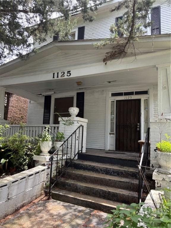 1125 E Anderson St, Savannah, GA 31404 - view of exterior entry featuring a porch and brick siding