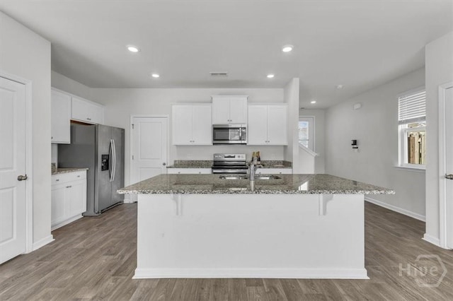 338 Wedge Cir, Richmond Hill, GA 31324 - kitchen featuring stainless steel appliances, a breakfast bar area, stone counters, a kitchen island with sink, and recessed lighting