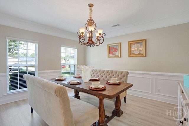 208 Chippingwood Cir, Pooler, GA 31322 - dining area with a wainscoted wall, a decorative wall, a chandelier, ornamental molding, and light wood finished floors