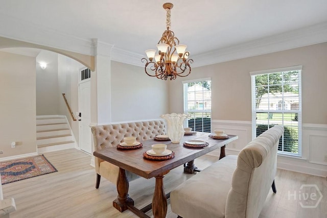 208 Chippingwood Cir, Pooler, GA 31322 - dining space featuring arched walkways, light wood-style floors, a chandelier, crown molding, and a wainscoted wall