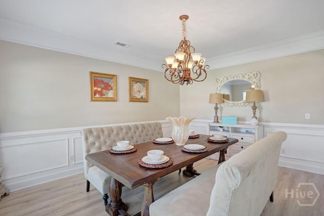 208 Chippingwood Cir, Pooler, GA 31322 - dining space with a chandelier, ornamental molding, wainscoting, light wood-style flooring, and a decorative wall