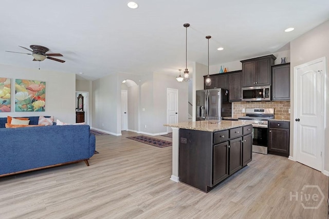 208 Chippingwood Cir, Pooler, GA 31322 - kitchen with appliances with stainless steel finishes, open floor plan, arched walkways, ceiling fan, and light wood-style flooring