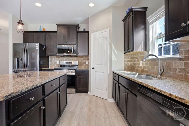 208 Chippingwood Cir, Pooler, GA 31322 - kitchen with appliances with stainless steel finishes, light wood finished floors, light stone counters, dark brown cabinets, and tasteful backsplash