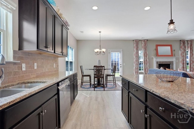 208 Chippingwood Cir, Pooler, GA 31322 - kitchen with stainless steel dishwasher, a brick fireplace, light wood-type flooring, tasteful backsplash, and decorative light fixtures