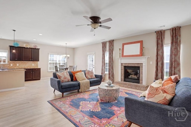 208 Chippingwood Cir, Pooler, GA 31322 - living room with ceiling fan, light wood-style floors, a brick fireplace, a chandelier, and recessed lighting
