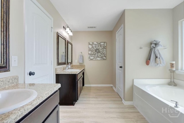 208 Chippingwood Cir, Pooler, GA 31322 - full bathroom with two vanities, wood finished floors, and a garden tub