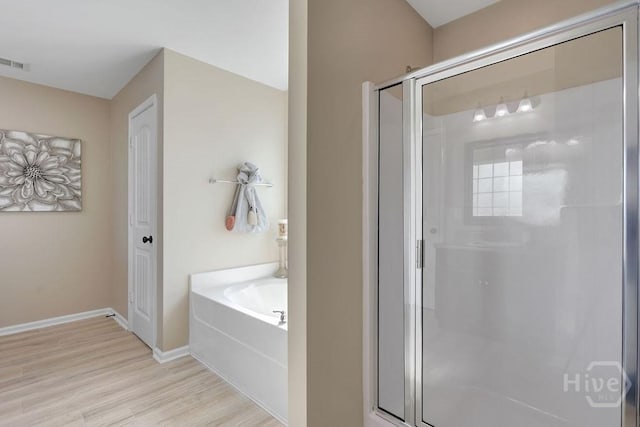 208 Chippingwood Cir, Pooler, GA 31322 - bathroom featuring a shower stall, a bath, and wood finished floors
