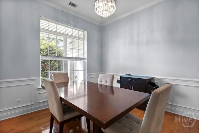 204 Bristol Way, Richmond Hill, GA 31324 - dining room with a chandelier, crown molding, a decorative wall, wainscoting, and wood finished floors
