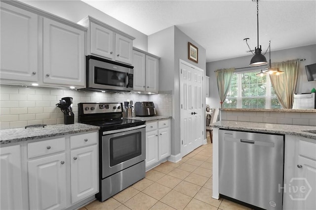 204 Bristol Way, Richmond Hill, GA 31324 - kitchen featuring stainless steel appliances, light tile patterned flooring, backsplash, and hanging light fixtures