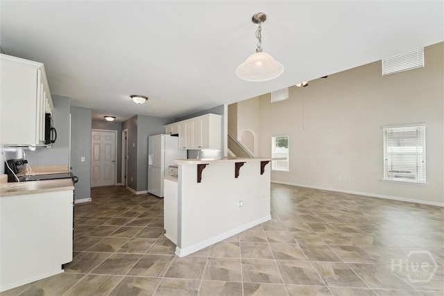 205 Summer Hill Ct, Richmond Hill, GA 31324 - kitchen featuring freestanding refrigerator, black microwave, light tile patterned flooring, and a breakfast bar area