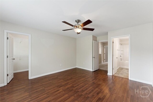 205 Summer Hill Ct, Richmond Hill, GA 31324 - unfurnished bedroom with dark wood-style floors, a walk in closet, and a ceiling fan