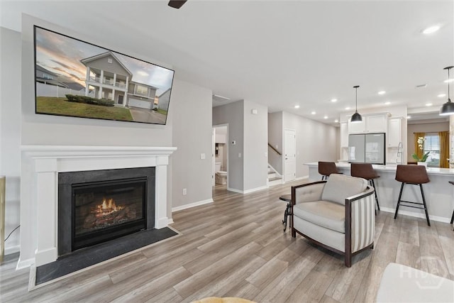 103 Williams Dr, Rincon, GA 31326 - living room featuring light wood-style floors, a fireplace with flush hearth, stairway, and recessed lighting