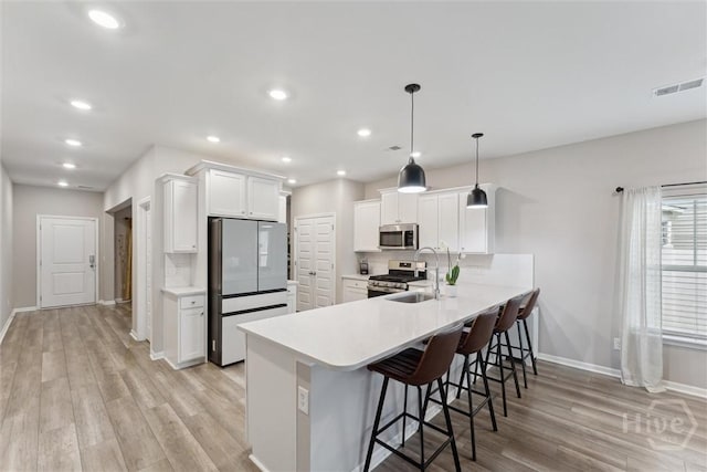 103 Williams Dr, Rincon, GA 31326 - kitchen featuring appliances with stainless steel finishes, a peninsula, light countertops, a kitchen breakfast bar, and recessed lighting