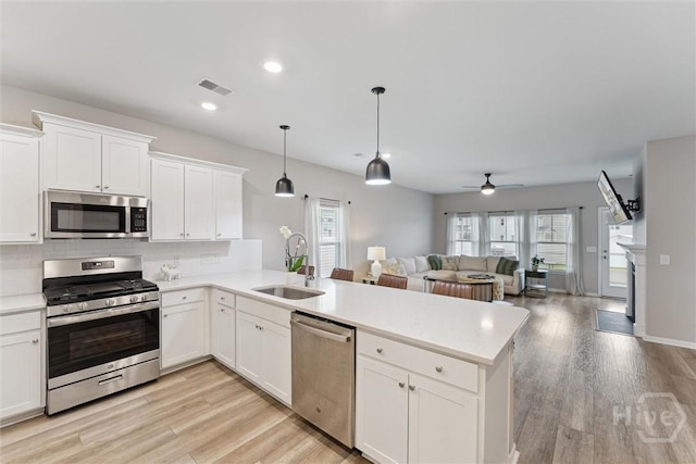 103 Williams Dr, Rincon, GA 31326 - kitchen with stainless steel appliances, open floor plan, a peninsula, light countertops, and recessed lighting