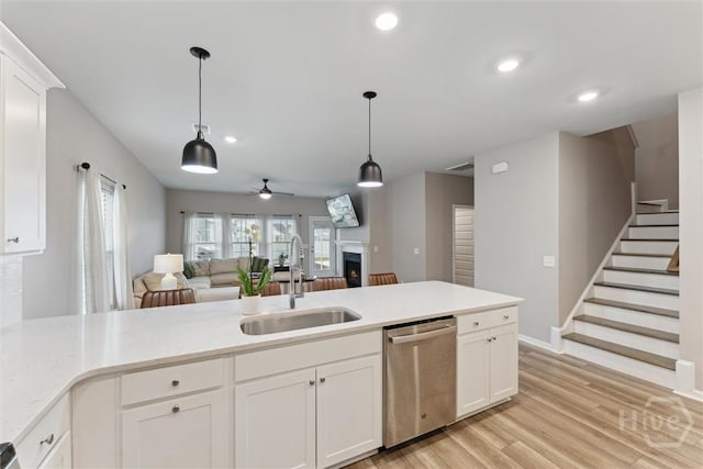 103 Williams Dr, Rincon, GA 31326 - kitchen featuring stainless steel dishwasher, a lit fireplace, open floor plan, a ceiling fan, and recessed lighting
