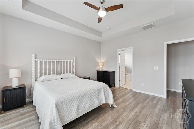 103 Williams Dr, Rincon, GA 31326 - bedroom with a tray ceiling, light wood finished floors, connected bathroom, and ceiling fan