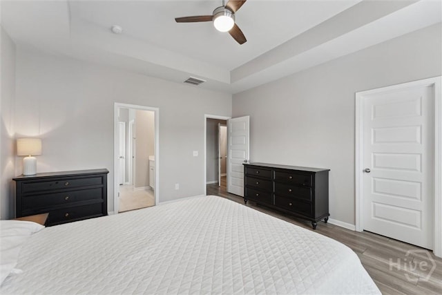 103 Williams Dr, Rincon, GA 31326 - bedroom featuring wood finished floors, ensuite bathroom, a raised ceiling, and ceiling fan