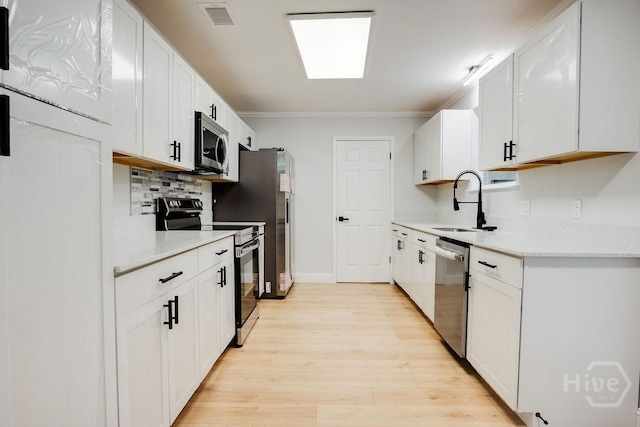 12902 Canterbury Rd, Savannah, GA 31419 - kitchen with stainless steel appliances, light wood-style floors, light countertops, ornamental molding, and backsplash