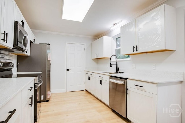 12902 Canterbury Rd, Savannah, GA 31419 - kitchen featuring appliances with stainless steel finishes, light wood finished floors, ornamental molding, white cabinetry, and light countertops