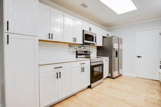 12902 Canterbury Rd, Savannah, GA 31419 - kitchen with appliances with stainless steel finishes, light wood finished floors, light countertops, decorative backsplash, and ornamental molding