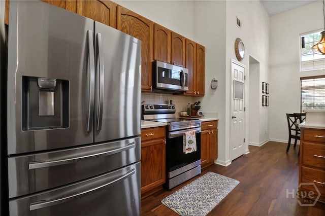 117 Barrington Rd, Pooler, GA 31322 - kitchen with appliances with stainless steel finishes, brown cabinetry, dark wood finished floors, and a high ceiling