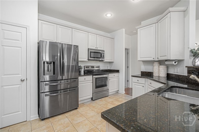 141 Regency Cir, Pooler, GA 31322 - kitchen featuring stainless steel appliances, light tile patterned flooring, recessed lighting, dark stone countertops, and white cabinetry