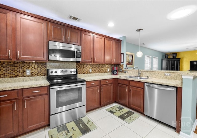 335 Winchester Dr, Pooler, GA 31322 - kitchen featuring appliances with stainless steel finishes, a peninsula, decorative backsplash, hanging light fixtures, and light stone countertops