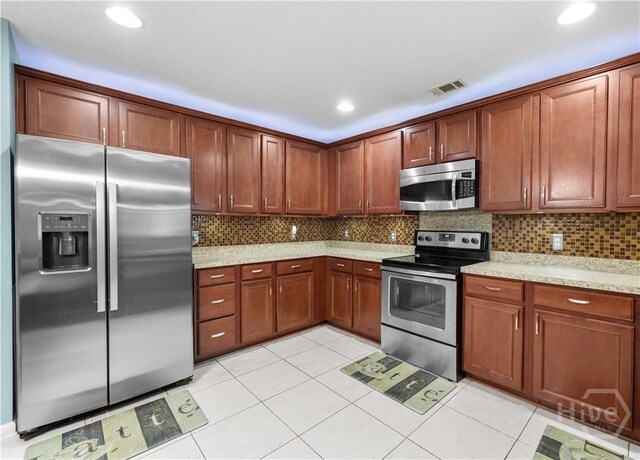 335 Winchester Dr, Pooler, GA 31322 - kitchen featuring appliances with stainless steel finishes, light tile patterned floors, backsplash, light stone countertops, and recessed lighting