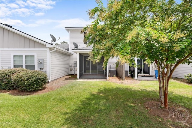 160 Lake Lily Dr, Richmond Hill, GA 31324 - back of property with a lawn, board and batten siding, and a sunroom