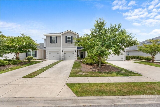 160 Lake Lily Dr, Richmond Hill, GA 31324 - view of front facade with board and batten siding, concrete driveway, and a garage