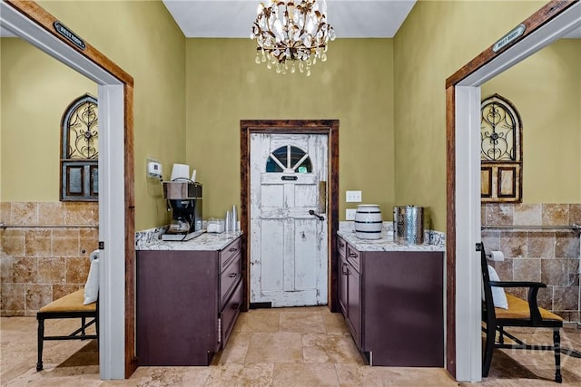438 Kessler Loop, Guyton, GA 31312 - foyer featuring tile walls, a chandelier, light stone finish floors, and wainscoting