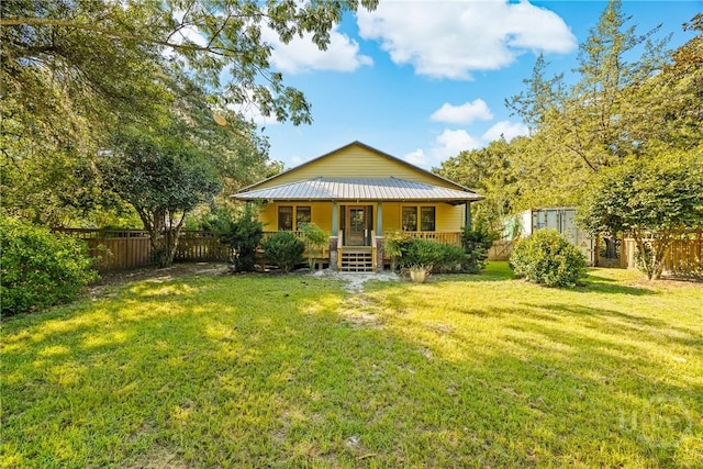 438 Kessler Loop, Guyton, GA 31312 - view of front of house with a porch, a fenced backyard, and a metal roof