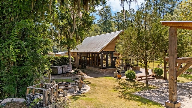 438 Kessler Loop, Guyton, GA 31312 - back of house featuring a metal roof, a jacuzzi, and a patio