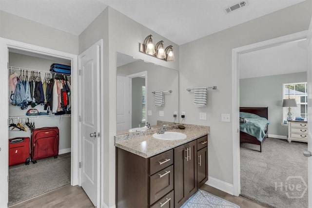 1237 Cypress Fall Cir, Hinesville, GA 31313 - full bathroom with vanity, a chandelier, wood finished floors, connected bathroom, and a walk in closet