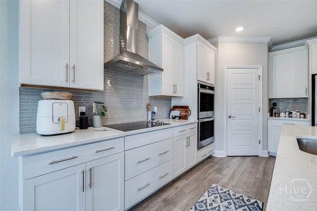 127 Champlain Dr, Pooler, GA 31322 - kitchen featuring wall chimney range hood, black electric stovetop, stainless steel double oven, crown molding, and white cabinets