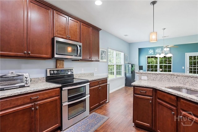 80 Sunbury Ct, Richmond Hill, GA 31324 - kitchen with stainless steel appliances, dark wood-style floors, hanging light fixtures, light stone counters, and recessed lighting